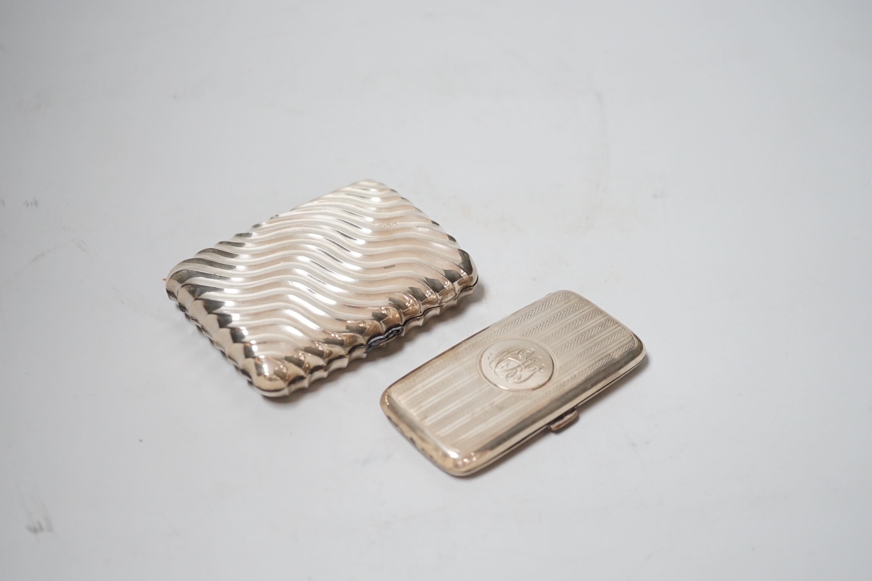 A late Victorian wrythened silver cigarette case, 88mm and a smaller silver cigarette case.